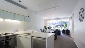 Une cuisine moderne avec un îlot central, un coin repas offrant une belle vue et une horloge au mur.