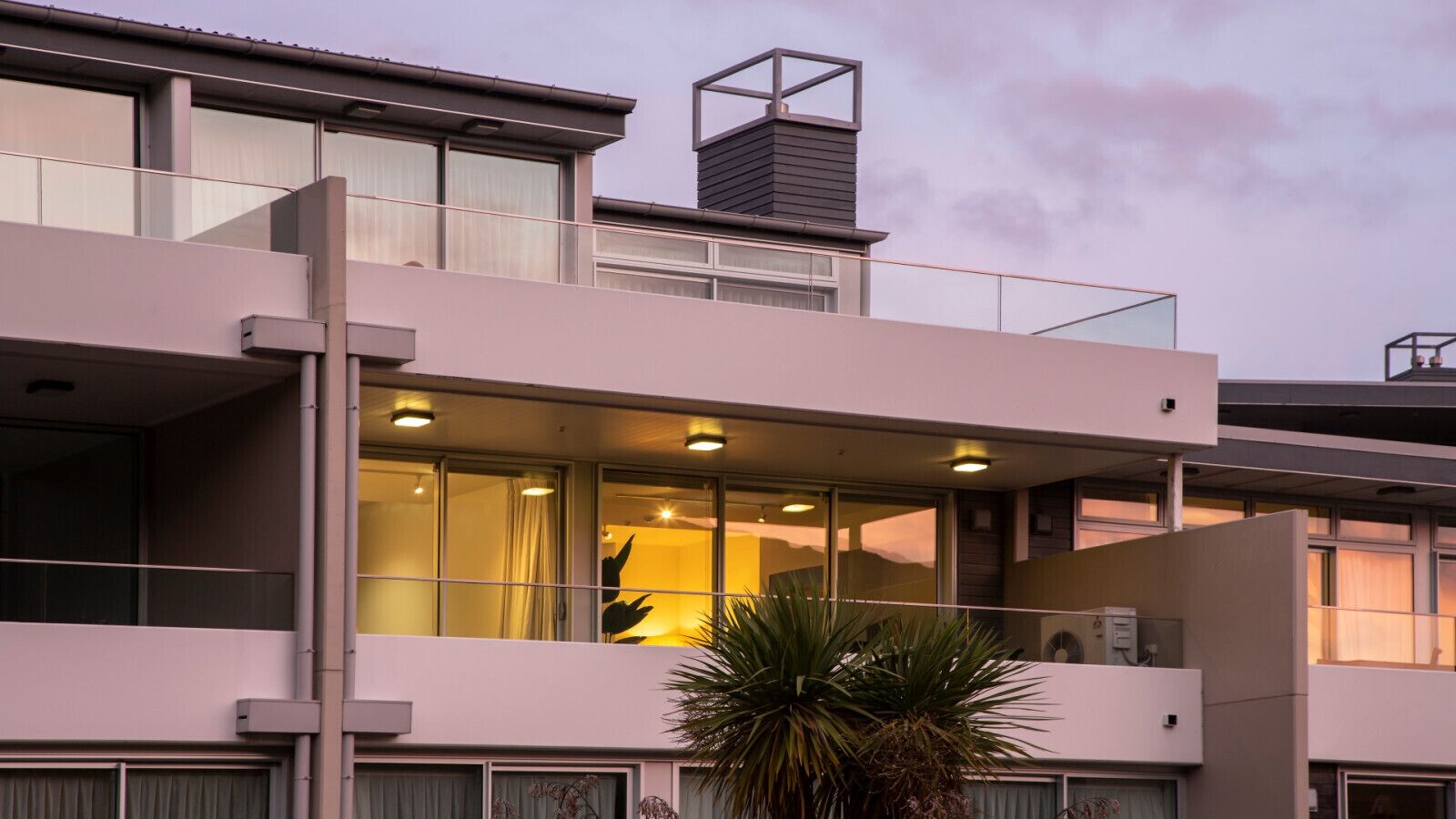 A modern multi-story building with large windows and balconies.