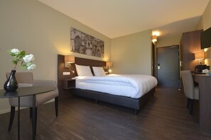Relax in a serene space with a large bed, bedside tables, and a flat-screen TV.