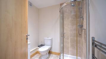 Une salle de bain avec douche, toilettes et baignoire.
