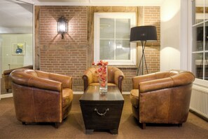 Relax in this inviting living room with a brick wall, comfortable armchairs, and a coffee table.