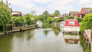 Un canal étroit, bordé de part et d’autre par des bateaux amarrés, et entouré d’immeubles d’habitation aux toits rouges.
