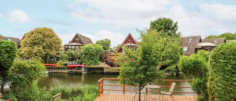 A riverside property with wooden decks, a small dock, and a boat.