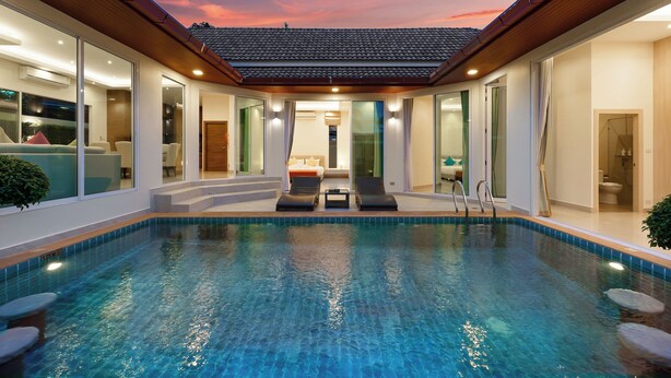 A modern indoor pool with clear blue water, surrounded by glass walls and wooden ceiling. - Luxury Pool Villa A14 3BR/8 Persons (Muang Pattaya)