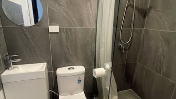 Chuveiro, toalhas de banho, sabonete, papel higiênico