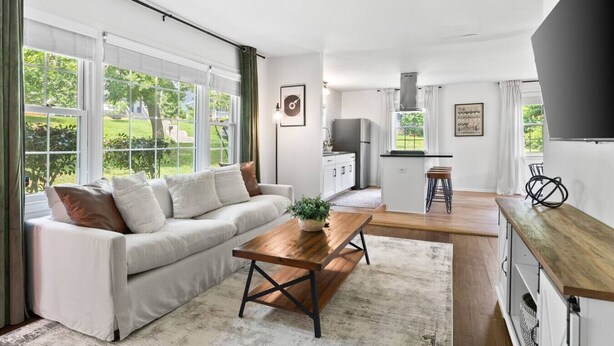 A modern living room with a sofa, coffee table, and kitchen area with a bar.