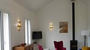 Una sala moderna con comedor, chimenea y televisor.