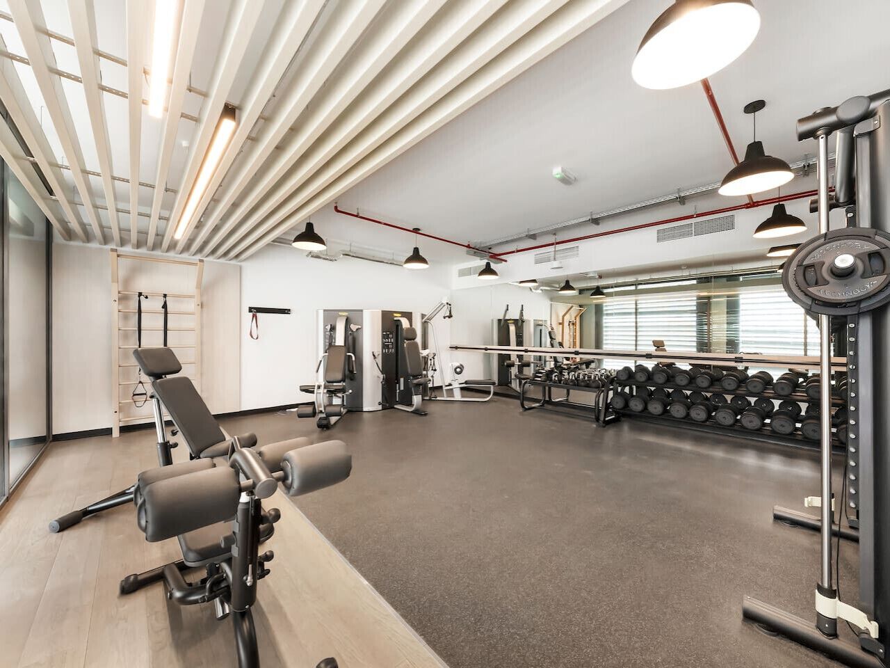 Een moderne sportschool met diverse fitnessapparaten, waaronder gewichten en krachtapparaten.