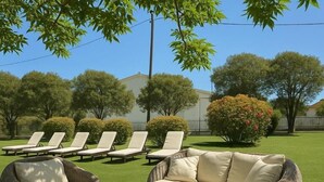 A patio with wicker furniture, including a sofa and chairs, and a round table. - Marina Studio (Corfu)