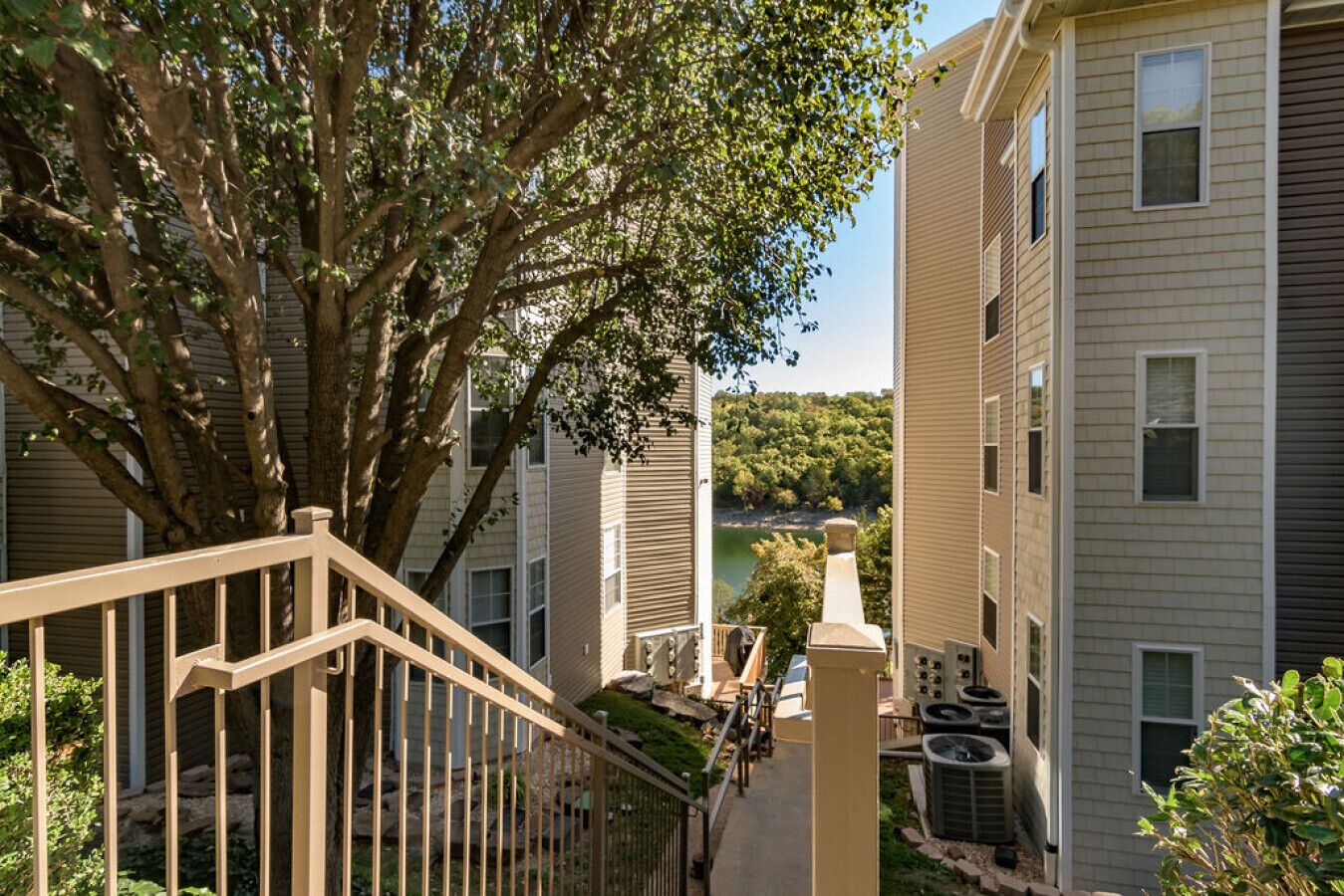 A residential building with a central courtyard, a tree, and a view of a lake.