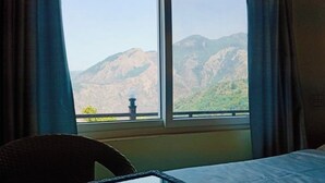 A room with a large window offering a mountain view. - Harika Palace hidden awayfrom city chaos (Nainital)