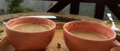 Two pink ceramic cups on a tray with popcorn.