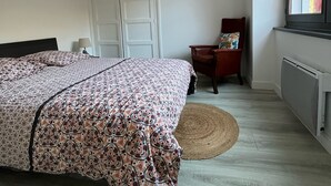 Makuuhuoneessa on sänky, tuoli, ikkuna ja patteri.