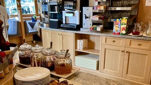 Een ontbijtbuffet met gebak, drankjes en toevoegingen.