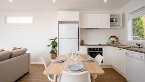 A modern kitchen with white cabinets, a built-in oven, and a dishwasher. - 5 mins walk to Beach - Modern Beachy Escape. Netflix, Full Kitchen, Comfy Beds! (Terrigal)