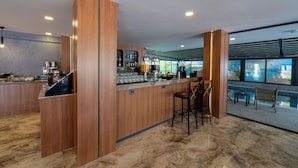 Una cocina moderna con detalles de madera, una barra y vistas a una piscina.