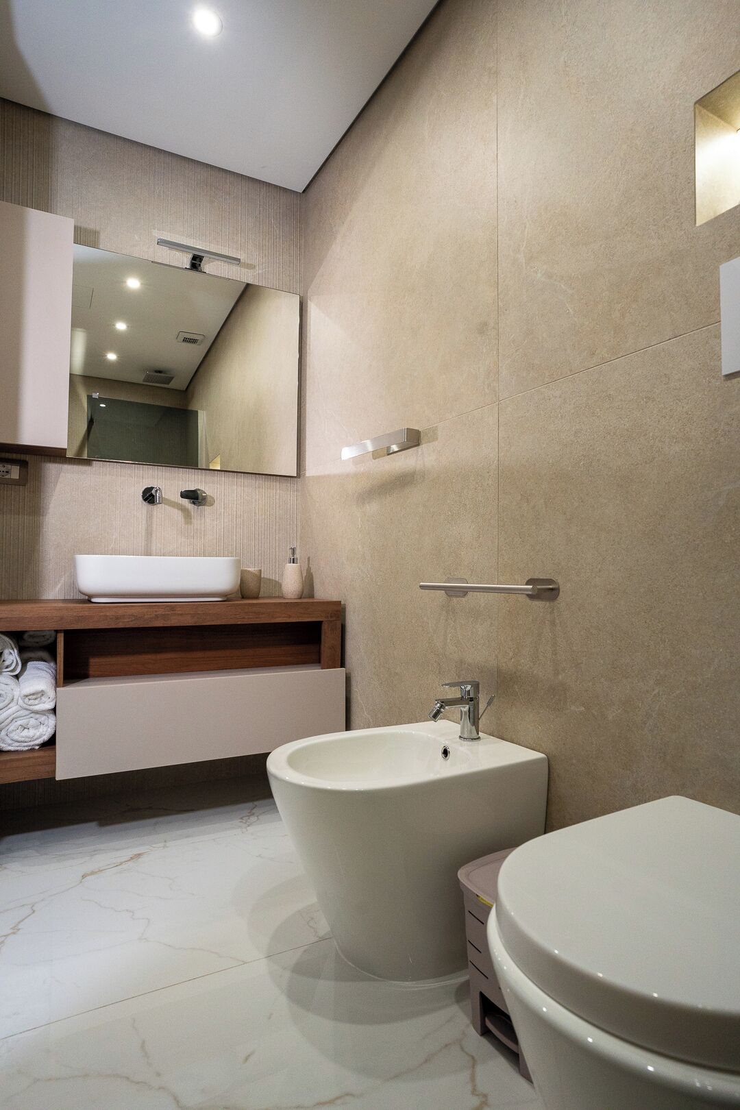 A modern bathroom with a freestanding bathtub, a vanity with a mirror, and a separate sink.