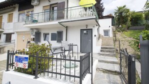 Un immeuble de deux étages doté d’un balcon, d’un parasol jaune et d’un panneau indiquant qu’il est interdit de se garer.