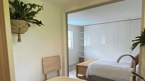 A modern bathroom with a freestanding bathtub, a wooden bench, and a hanging plant. - Villa with pool, 15 min walk from the beach (Hendaye)