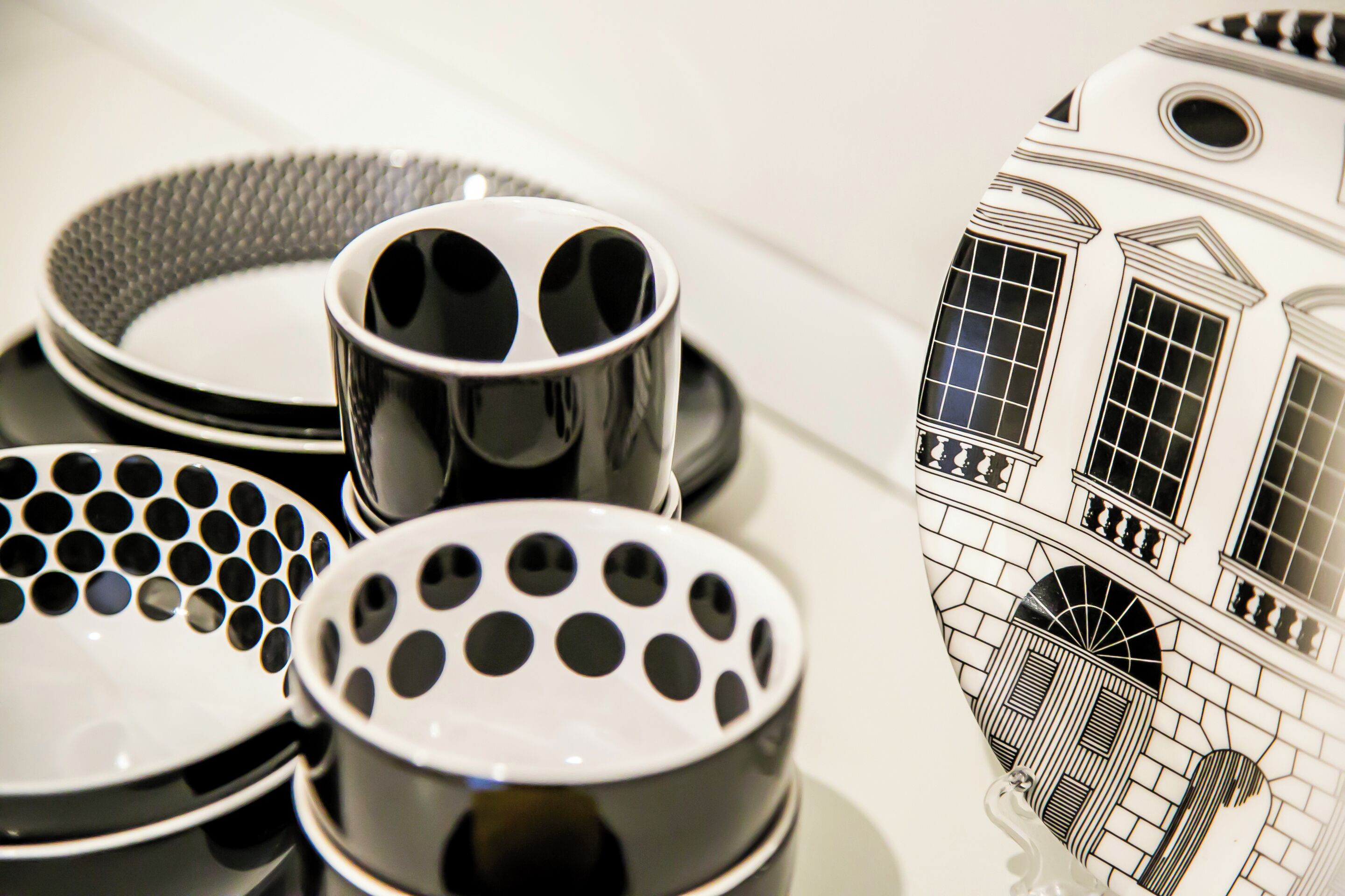 A collection of black and white patterned plates and a decorative item with a building illustration.