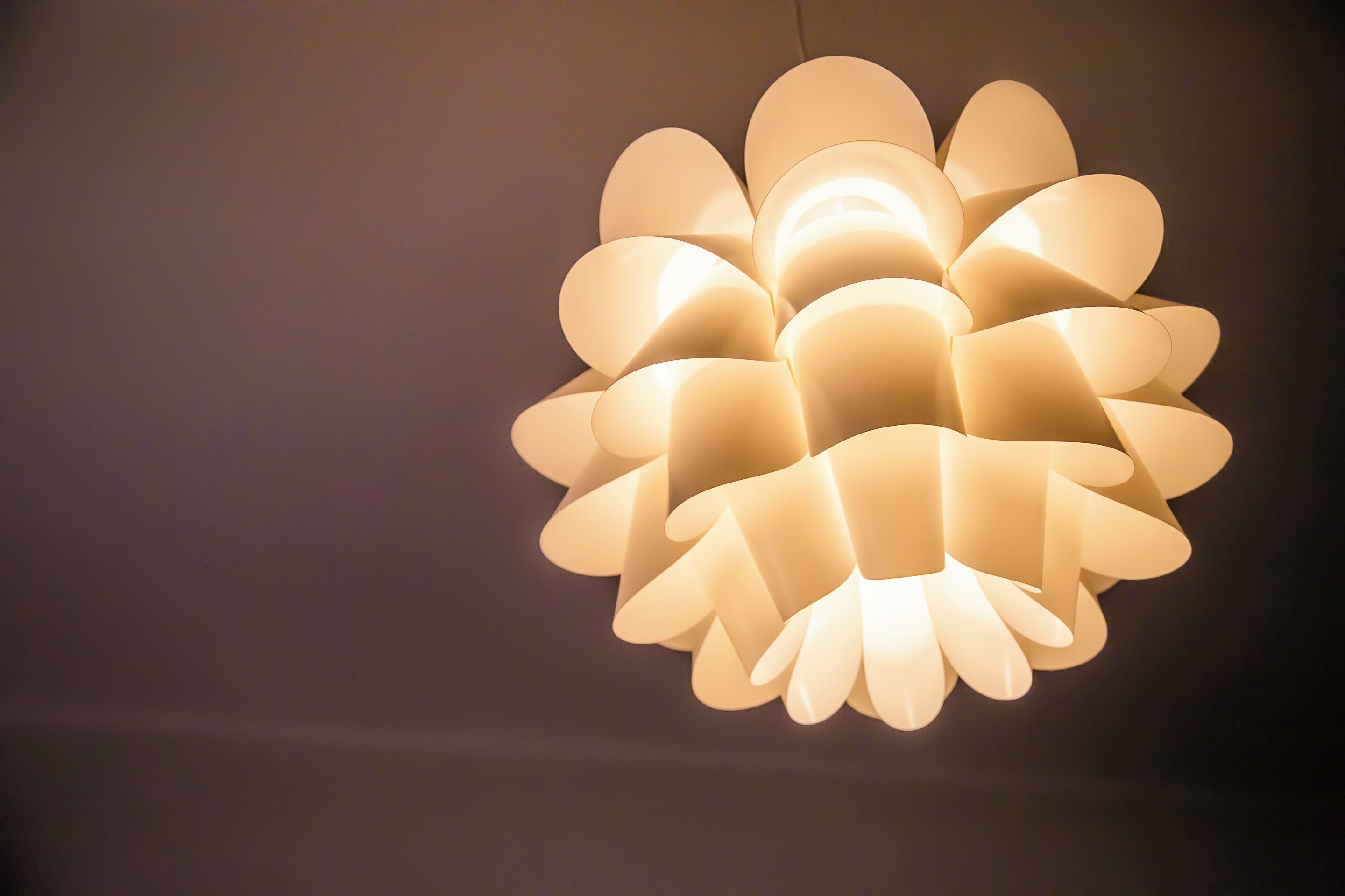 A hanging light fixture with multiple layers of petals.