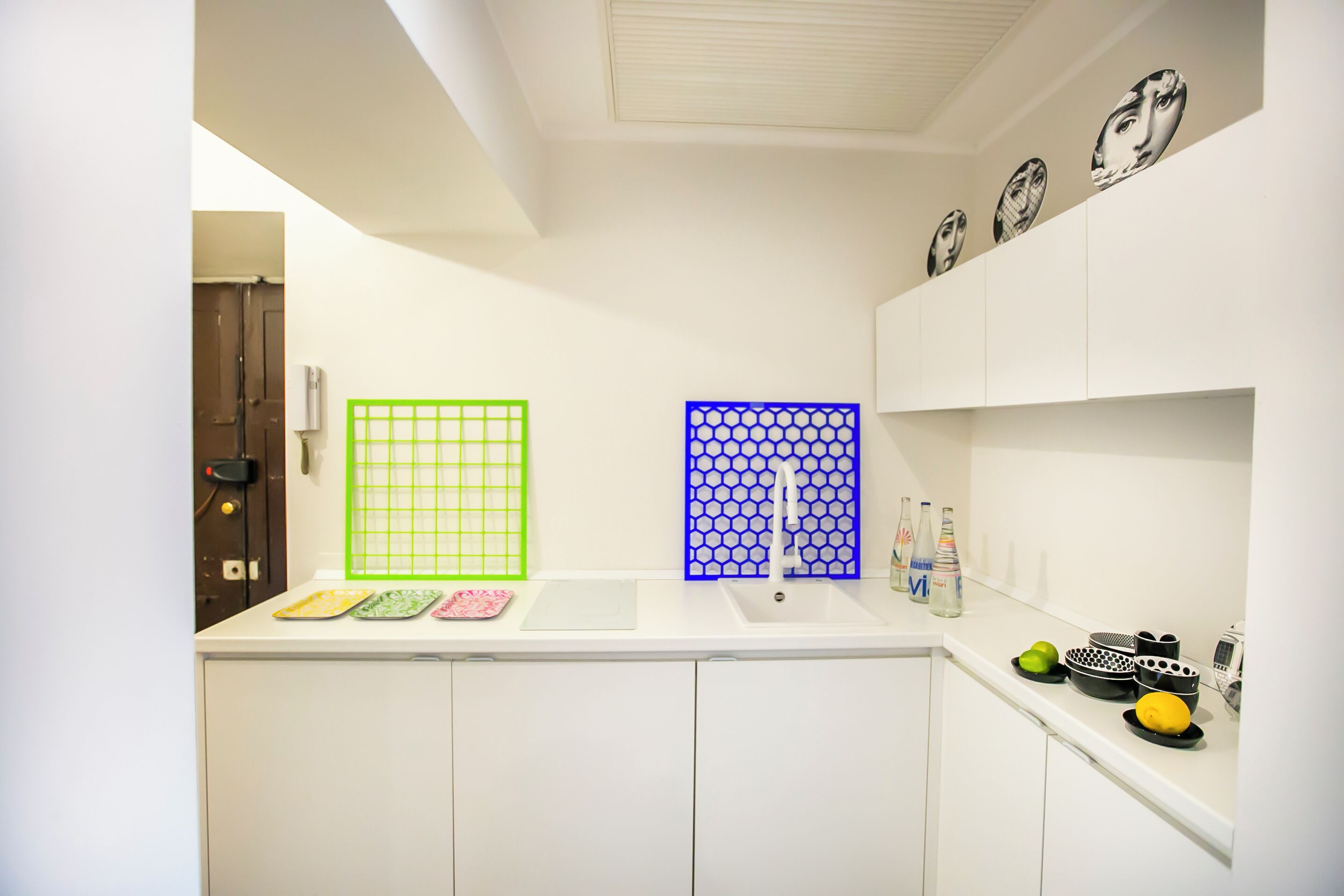 A kitchen with a white countertop, a sink, and a window with a grid pattern.