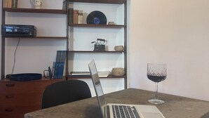 A room with a laptop on a table, a wine glass, and a clock on the wall. - Central Boutique Apartment for2 (Roma)