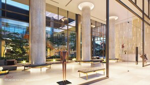 Un vestíbulo amplio con techos altos, grandes columnas y una escultura central.