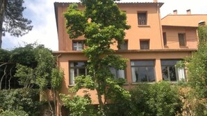 Un edificio de dos pisos con un jardín delantero.
