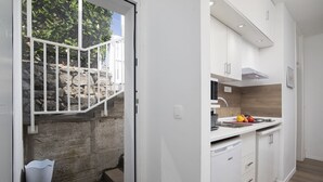 A modern kitchen with white cabinets, a built-in oven, and a sink.