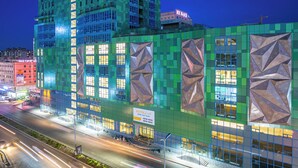 Un edificio moderno con fachada verde y ventanas amplias.