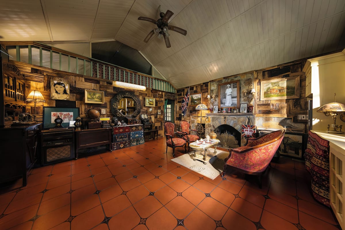 A cozy, well-decorated room with a fireplace, comfortable seating, and a variety of wall-mounted decorations.