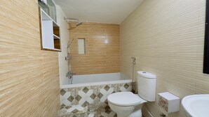 Une salle de bain avec une baignoire, des toilettes et un lavabo.