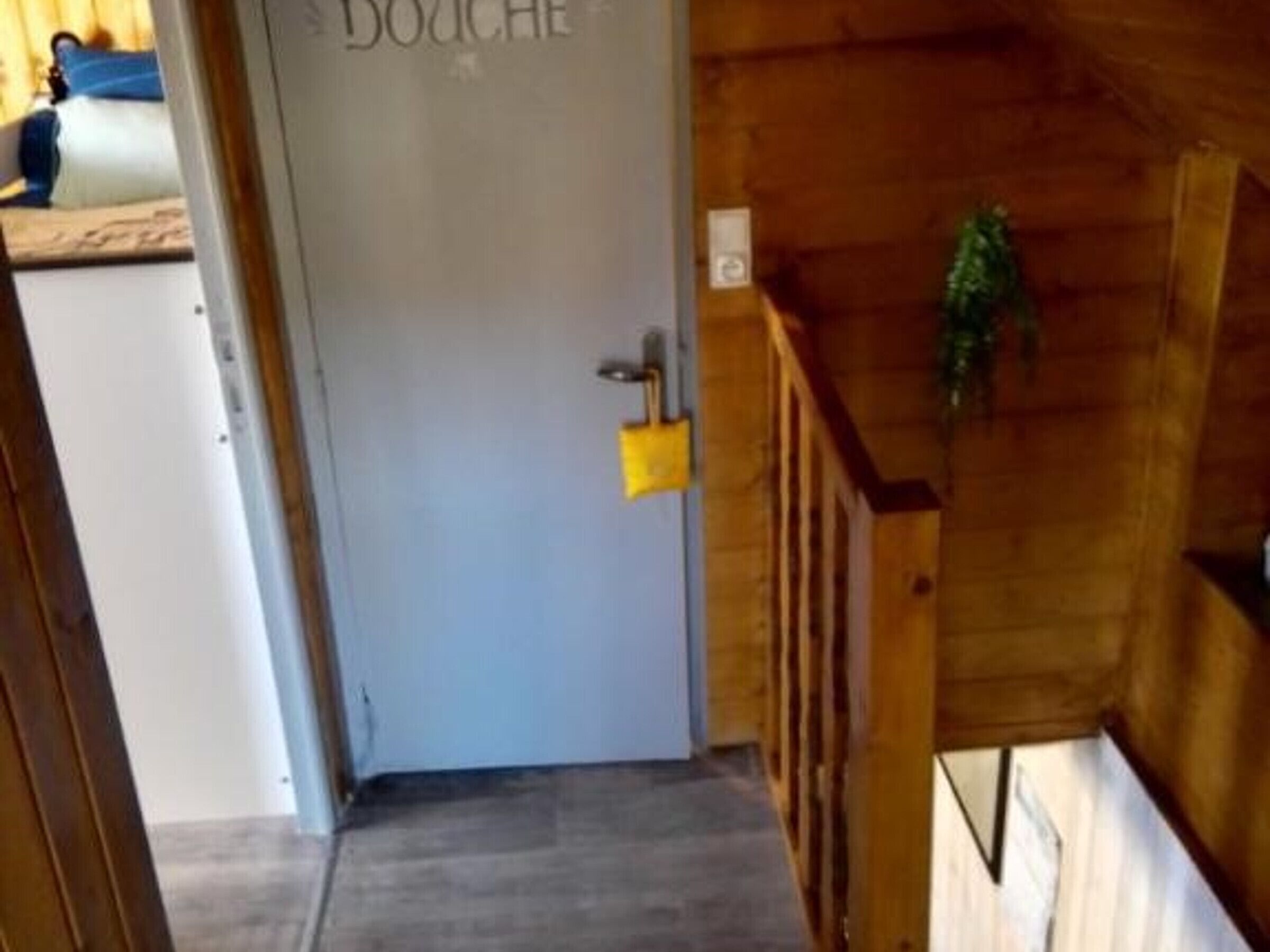 Un interno in legno con una porta con su scritto 'DOUCHE'.