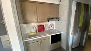 A compact kitchen with beige cabinets, a sink, and a built-in oven. - Beachfront apartment for 4 with parking (Argelès-sur-Mer)