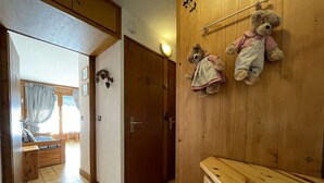 Una habitación de madera con una cama, un aparador de madera y dos osos de peluche en la pared.