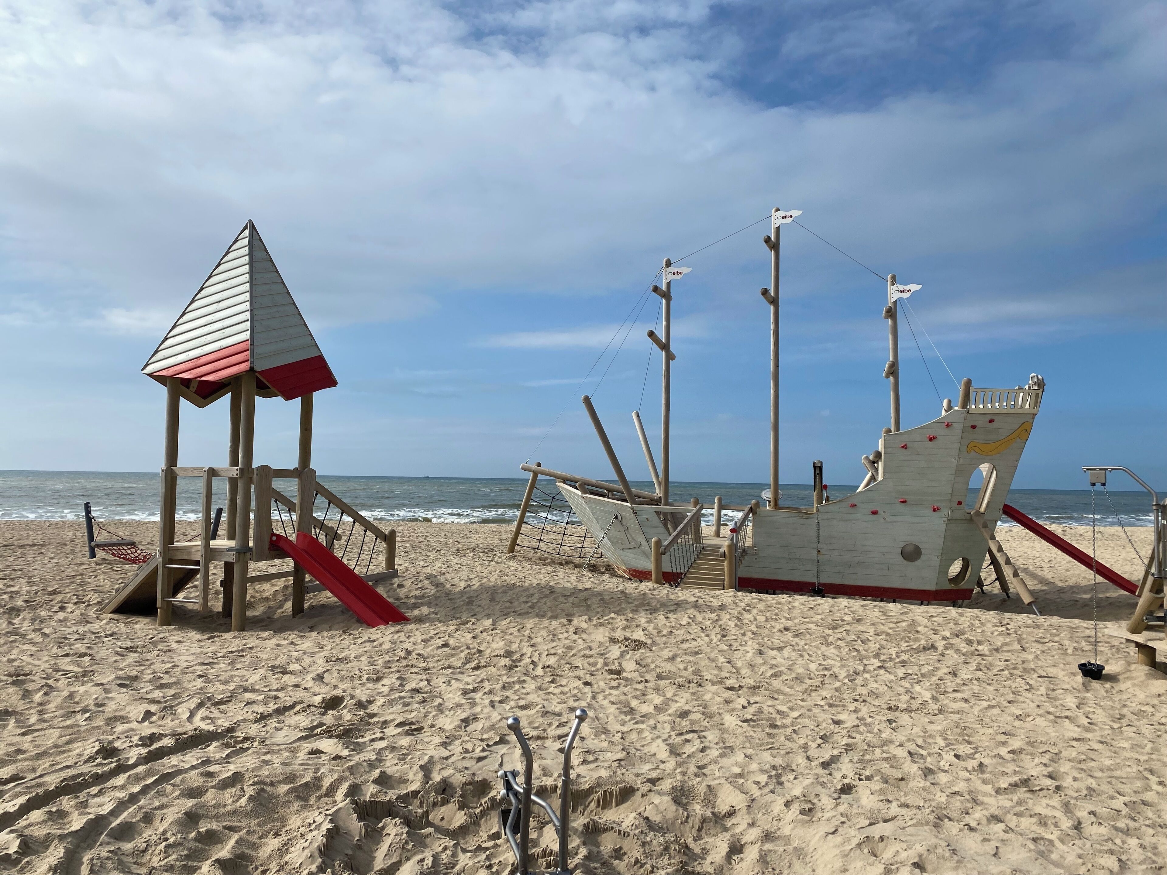 Una playa con una torre de salvavidas y los restos de un naufragio.