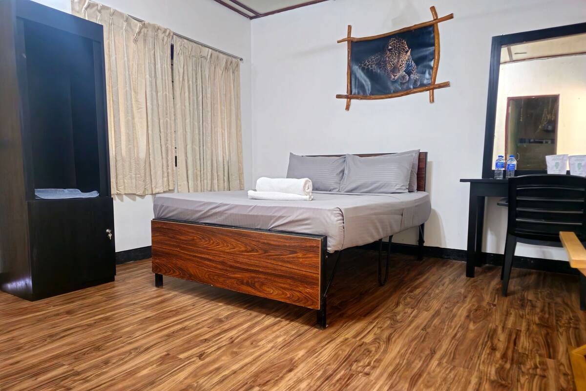 Un dormitorio con una cama de madera, un escritorio y una silla.
