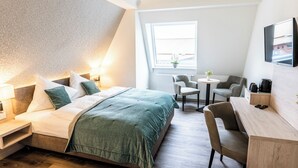 Una habitación de hotel moderna con cama, escritorio y zona de estar.
