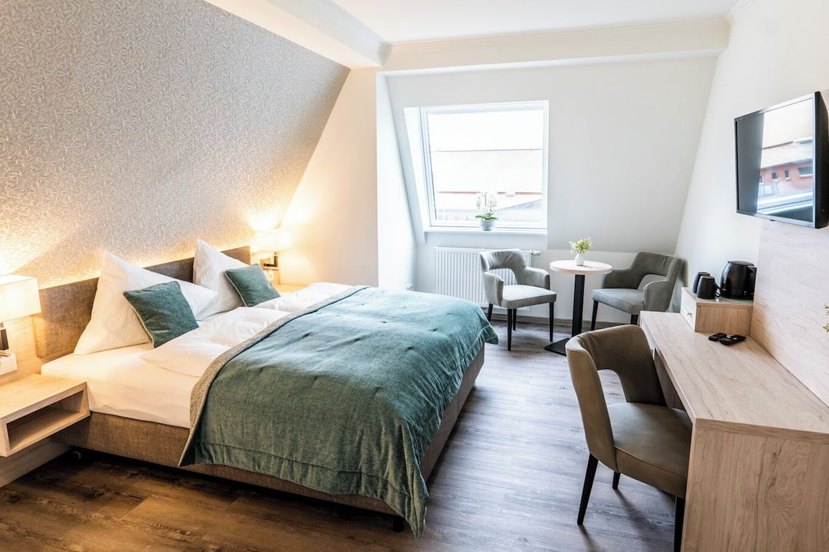 Una habitación de hotel moderna con cama, escritorio y zona de estar.