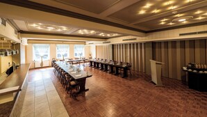 Una amplia sala de conferencias con una larga mesa, múltiples sillas y un atril.