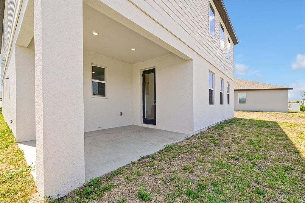 Una casa de un piso con un porche cubierto, una puerta y un ventanal pequeño.