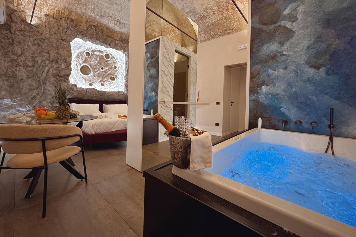 Un baño moderno con una bañera grande, zona de ducha y un rincón de descanso con una mesa.