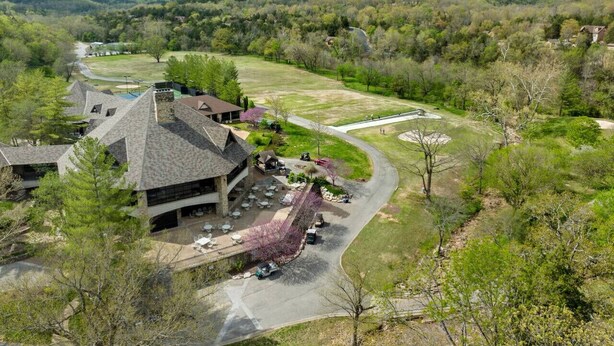 A large building with a parking lot and a golf course in the background.