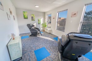 Relax in comfort with a massage chair, city views, and artwork adorning the walls.