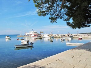 A marina with various boats docked, a pier, and a clear sky.