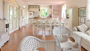 A spacious kitchen with white cabinetry and a dining area with wicker chairs. - Wonderful private villa for 6 guests with A/C, WIFI, TV, patio, pets allowed and panoramic view (Roccastrada)