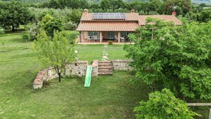 A house with a tiled roof, a patio with outdoor furniture, and a green lawn. - Wonderful private villa for 6 guests with A/C, WIFI, TV, patio, pets allowed and panoramic view (Roccastrada)