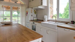 A kitchen with white cabinets, a wooden countertop, a built-in oven, and a window with a view of greenery. - Wonderful private villa for 6 guests with A/C, WIFI, TV, patio, pets allowed and panoramic view (Roccastrada)