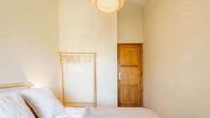 Une chambre à coucher avec un lit, une armoire en bois et un étendoir à linge.
